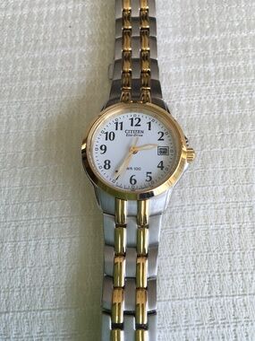 Citizen women’s goldtone and silver wristwatch with white face